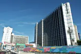 Dark glass hotel tower with Bally's signage and the Grand Bazaar Shops canopy in front
