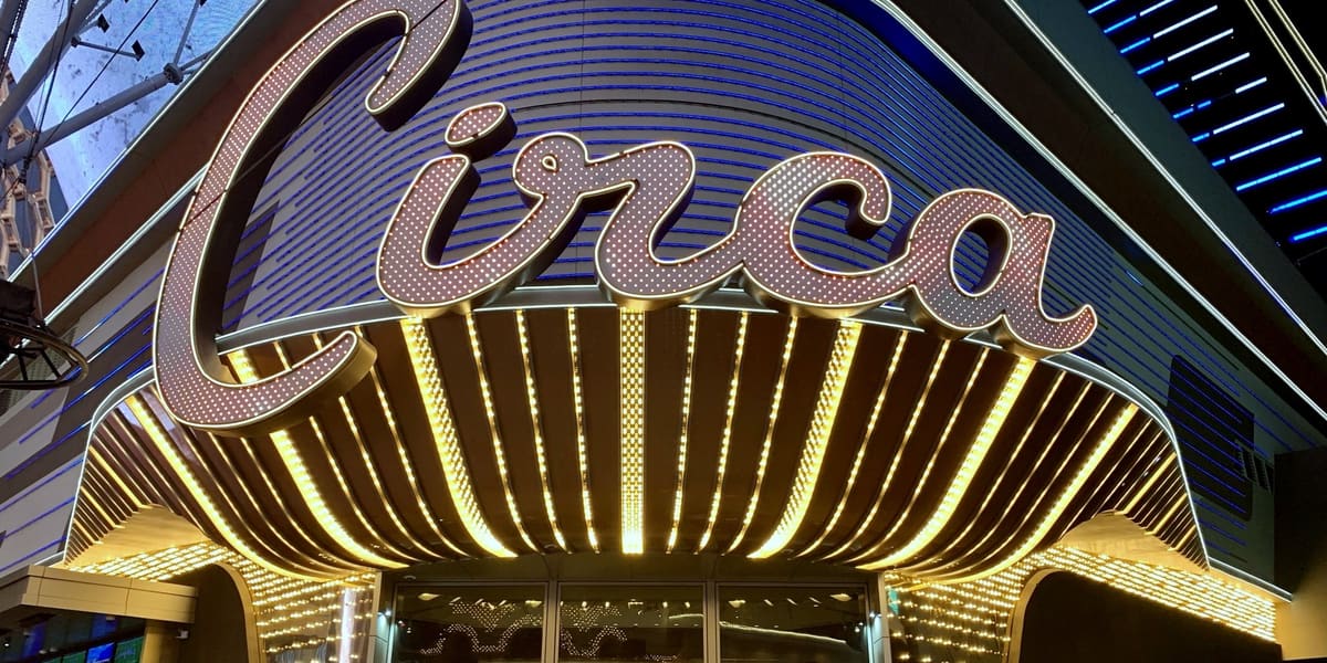 Illuminated Circa script sign above a gold-lit entrance canopy on Fremont Street at night