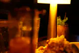 Cocktails and a small plate on a dimly lit table under the warm glow of a table lamp