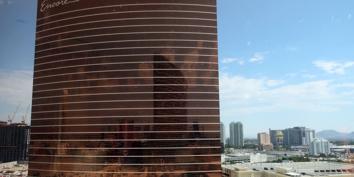 The curved bronze Encore tower with its signature script logo, seen from a high vantage point