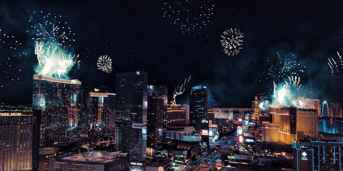 Fireworks bursting above Las Vegas Strip hotel towers at night, seen from above