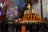 Crowds under the lit Fremont Street Experience canopy beside the Four Queens neon sign at night