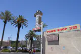 Gold & Silver Pawn shop sign and storefront on Las Vegas Boulevard under a clear blue sky with palm trees