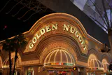 Golden Nugget's illuminated gold arch sign and canopied entrance on Fremont Street at night