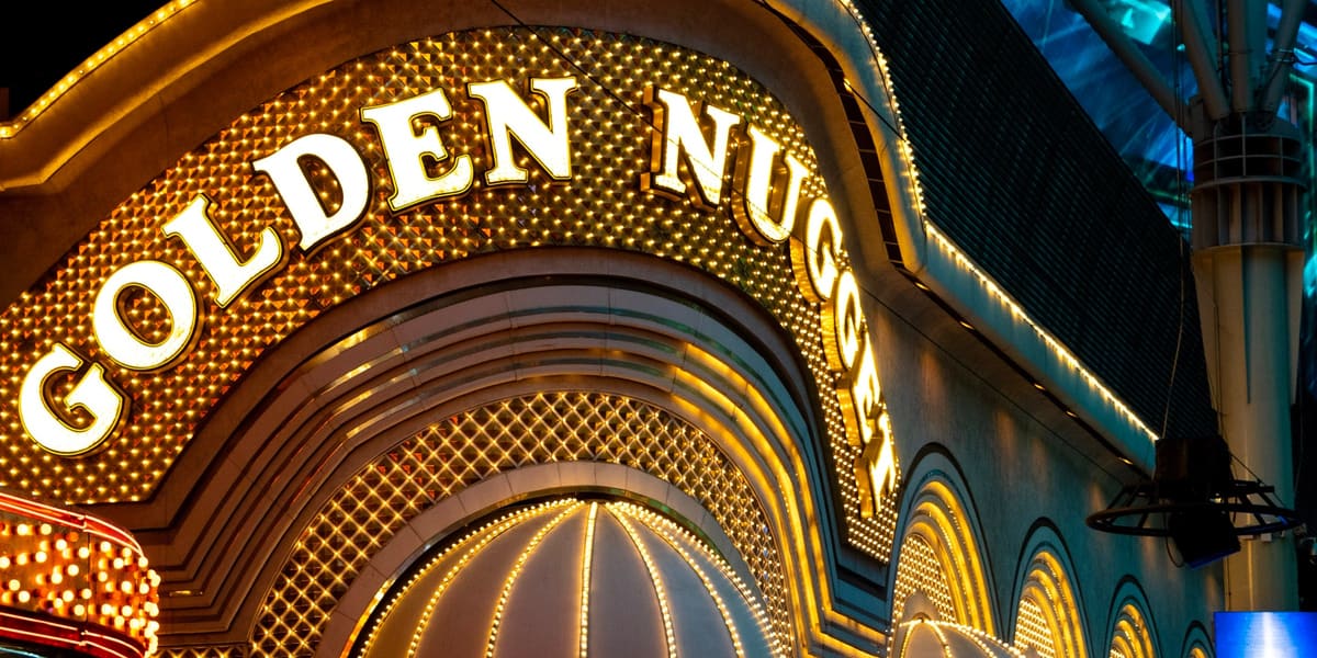 The Golden Nugget's arched gold sign and lightbulb-lined entrance awnings lit up at night