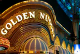 The Golden Nugget's arched gold sign and lightbulb-lined entrance awnings lit up at night