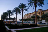 Palm-lined lawn and terraces in front of the Green Valley Ranch hotel tower at dusk