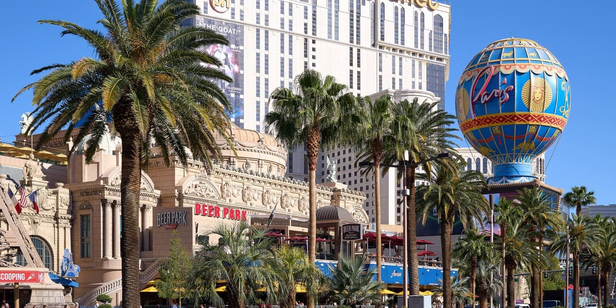 Palm trees along Las Vegas Boulevard with Planet Hollywood and the Paris Las Vegas balloon sign