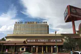Main Street Station hotel tower and casino frontage with its name in large letters under cloudy sky