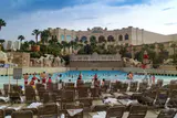 Rows of loungers in front of the sand-edged wave pool at Mandalay Bay Beach with palm trees beyond
