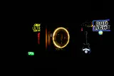 Neon beer signs and a glowing guitar-shaped sign on the wall of a dark bar