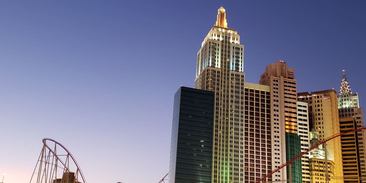 New York-New York's replica Manhattan skyline towers and roller coaster lit at dusk