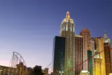New York-New York's replica Manhattan skyline towers and roller coaster lit at dusk