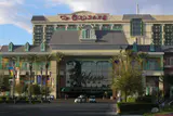 The Orleans hotel entrance and facade with its sign, palm trees and street in front
