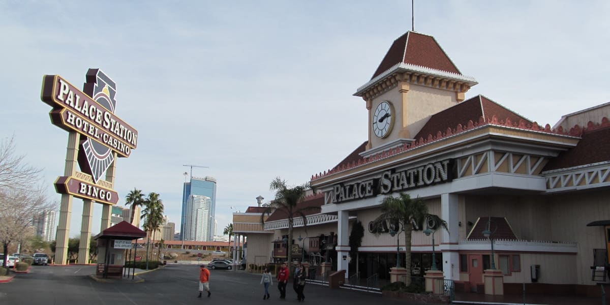 Palace Station's clock tower entrance and tall roadside sign under a pale sky