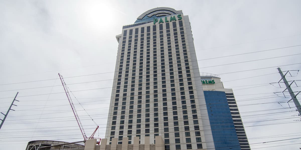 Palms hotel tower under an overcast sky with construction cranes beside it