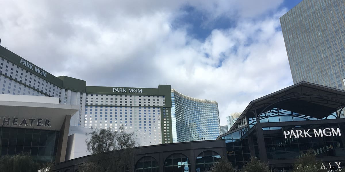 Park MGM hotel tower and entrance canopy with Park MGM signage under a cloudy sky