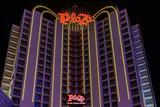 Plaza Hotel & Casino tower lit at night with red Plaza signs and gold arched lights