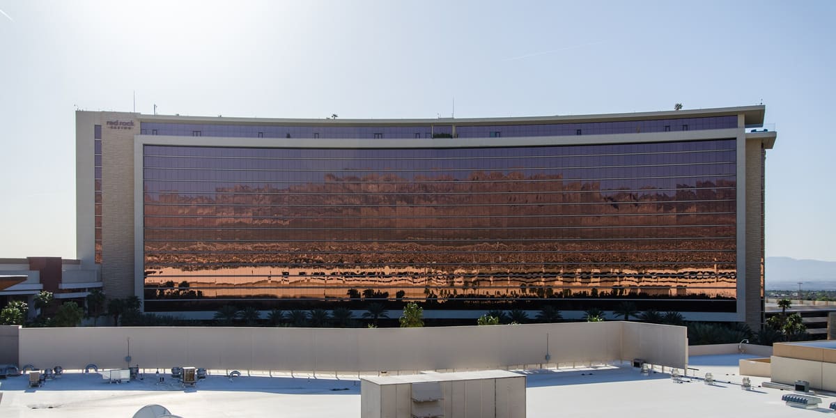The long low-rise Red Rock Resort hotel tower with reflective windows, seen across a flat rooftop