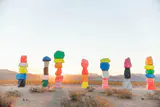 Brightly painted stacked boulder towers of Seven Magic Mountains in the desert at sunrise