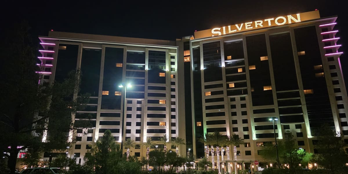 Silverton hotel towers at night with the Silverton name lit in gold and landscaped driveway