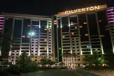 Silverton hotel towers at night with the Silverton name lit in gold and landscaped driveway