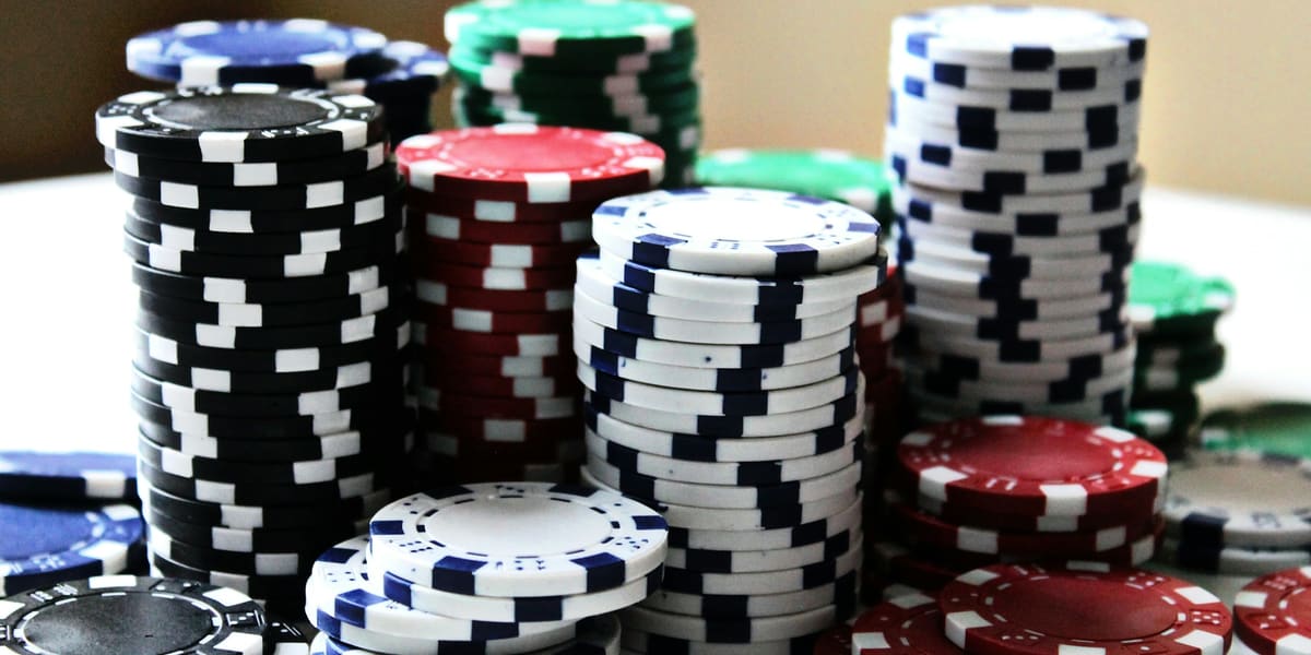 Tall stacks of black, red, blue, white and green poker chips on a table