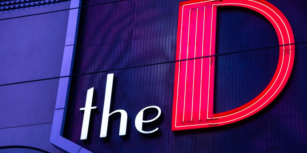 Red neon 'the D' sign on the purple facade of The D Las Vegas