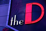 Red neon 'the D' sign on the purple facade of The D Las Vegas
