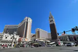 The Venetian's bell tower, Rialto-style bridge and hotel towers seen across Las Vegas Boulevard on a sunny day