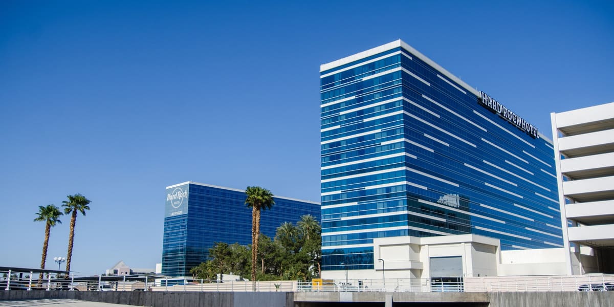 Blue glass hotel towers with Hard Rock Hotel signage beside a concrete flood channel