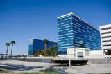 Blue glass hotel towers with Hard Rock Hotel signage beside a concrete flood channel